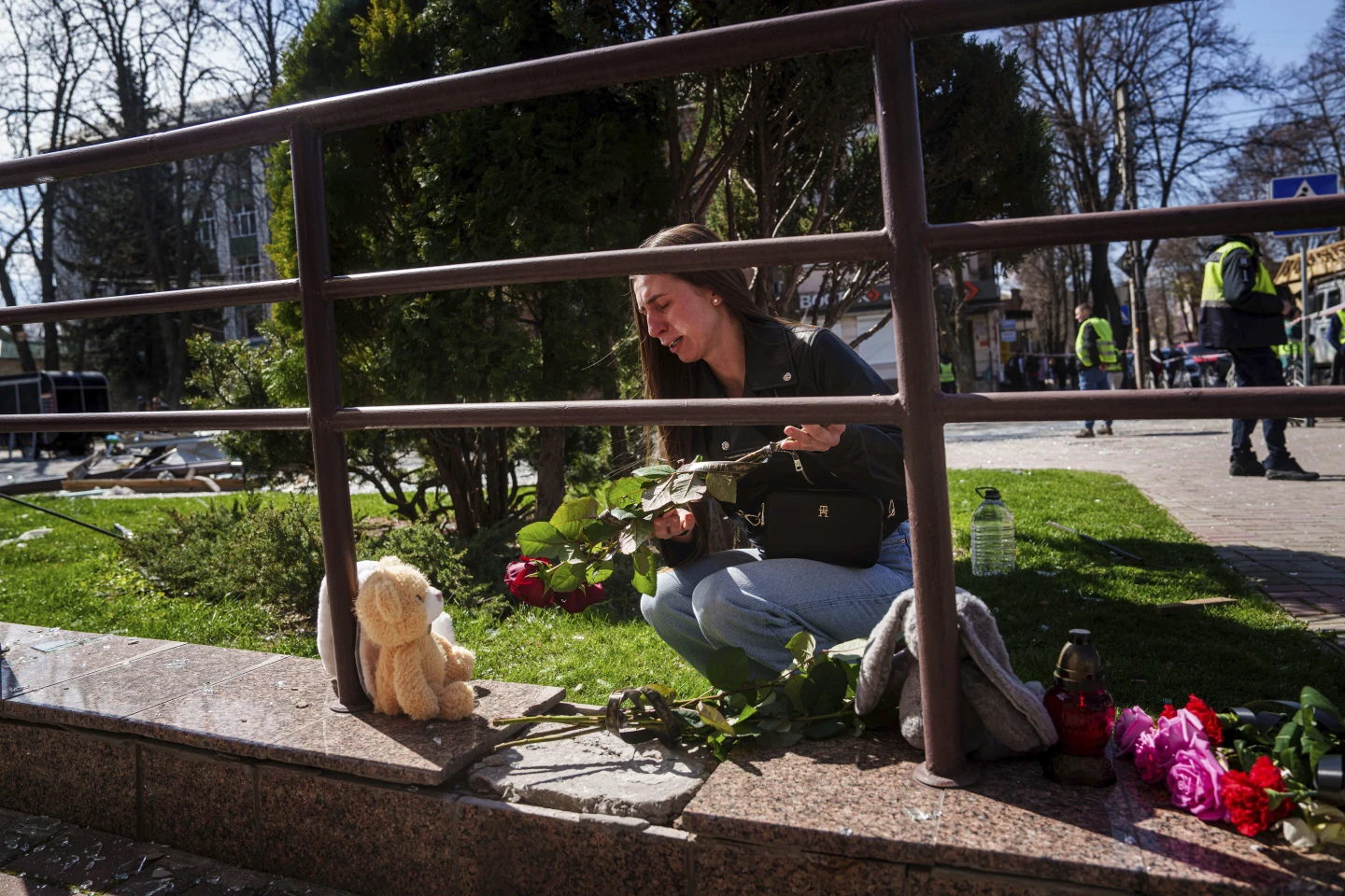 Катерина Сітак, 23 роки, вчителька, плаче під час покладання квітів та іграшок на місці російського ракетного удару в Сумах, Україна, понеділок, 14 квітня 2025 року.